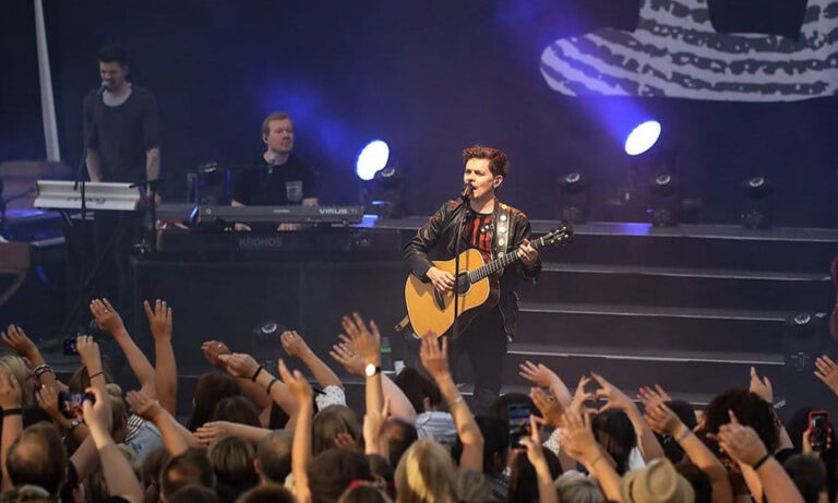 Michael Patrick Kelly steht mit seiner Gitarre live auf der Bühne im Amphitheater Hanau vor begeistertem Publikum.