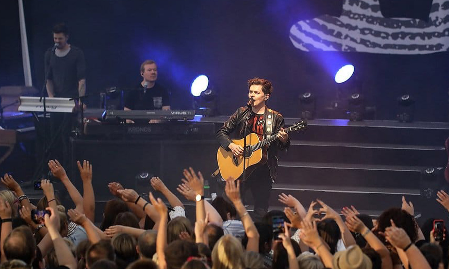 Michael Patrick Kelly steht mit seiner Gitarre live auf der Bühne im Amphitheater Hanau vor begeistertem Publikum.
