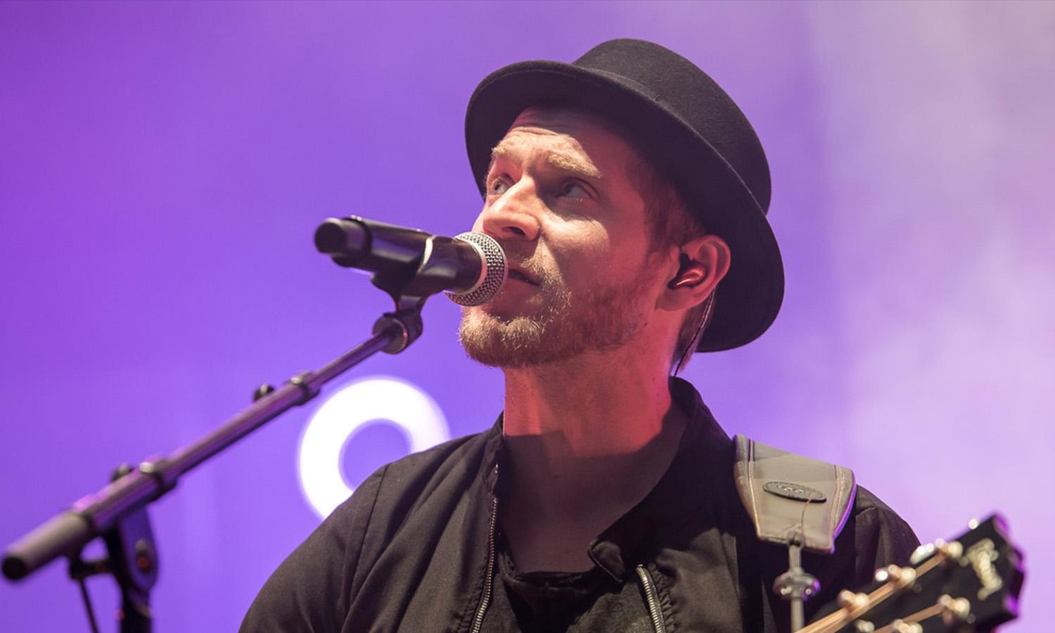 Sänger Johannes Oerding steht live mit seiner Akustikgitarre auf der Freilichtbühne am Kloster Schiffenberg in Gießen vor begeistertem Publikum.