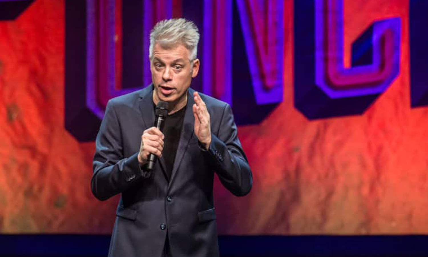 Comedian Michael Mittermeier steht gestisch und gut gelaunt live auf der Bühne in der Jahrhunderthalle Frankfurt vor Publikum.