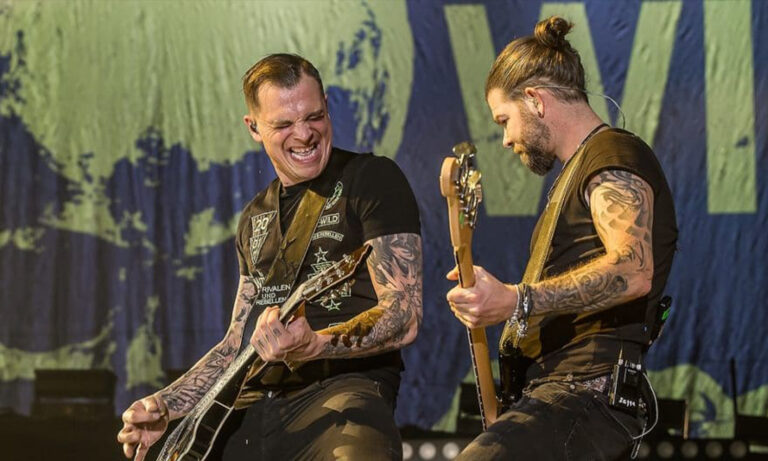 Frontmann Philipp Burger von Frei.Wild steht mit Gitarre energiegeladen auf der Bühne der ausverkauften Maimarkthalle Mannheim vor jubelnden Fans.