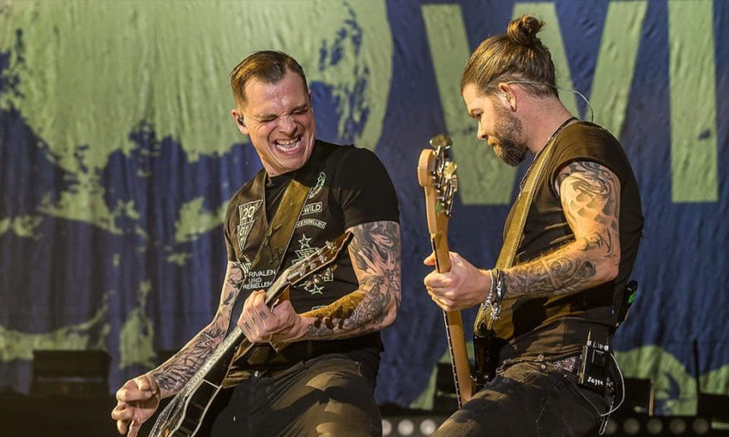 Frontmann Philipp Burger von Frei.Wild steht mit Gitarre energiegeladen auf der Bühne der ausverkauften Maimarkthalle Mannheim vor jubelnden Fans.