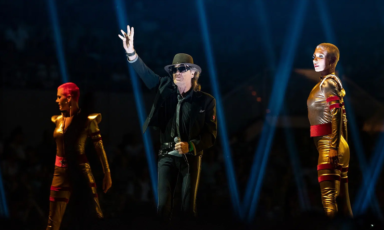Udo Lindenberg steht mit Hut und Sonnenbrille auf der farbenfroh beleuchteten Bühne der SAP Arena Mannheim.