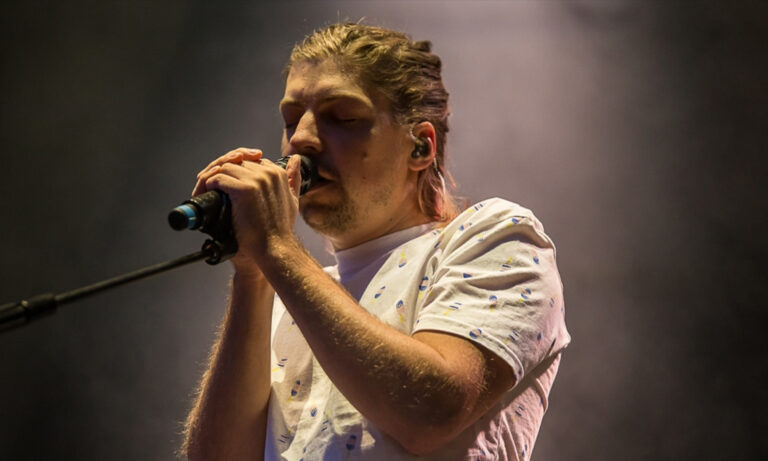 Philipp Poisel steht mit Gitarre auf der Open-Air-Bühne in Wetzlar und singt gefühlvoll.