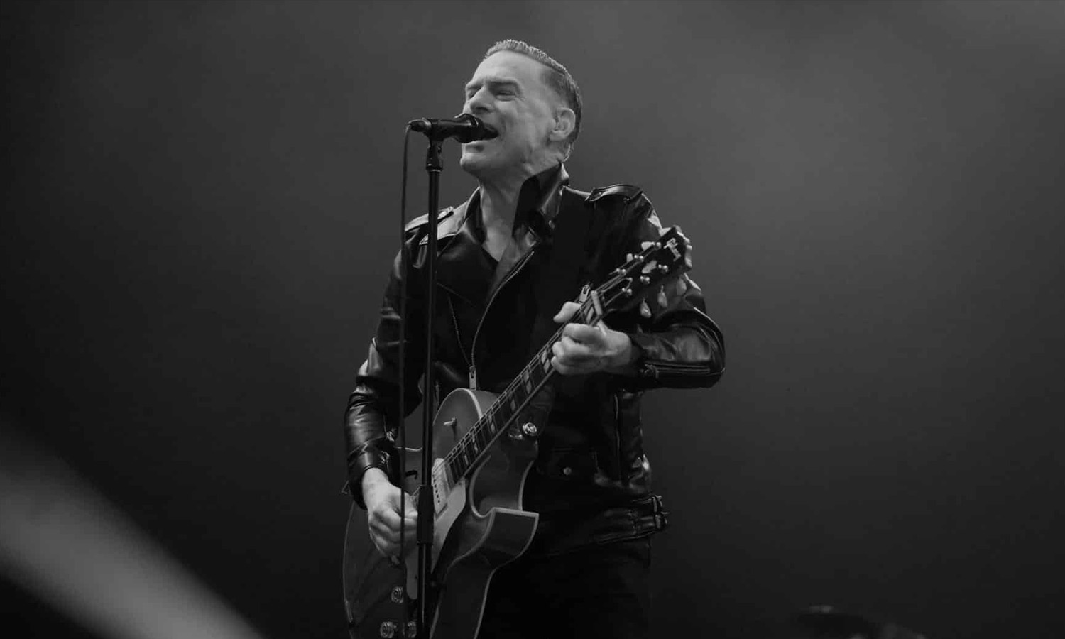 Bryan Adams singt und spielt Gitarre live auf der Bühne der SAP Arena in Mannheim.