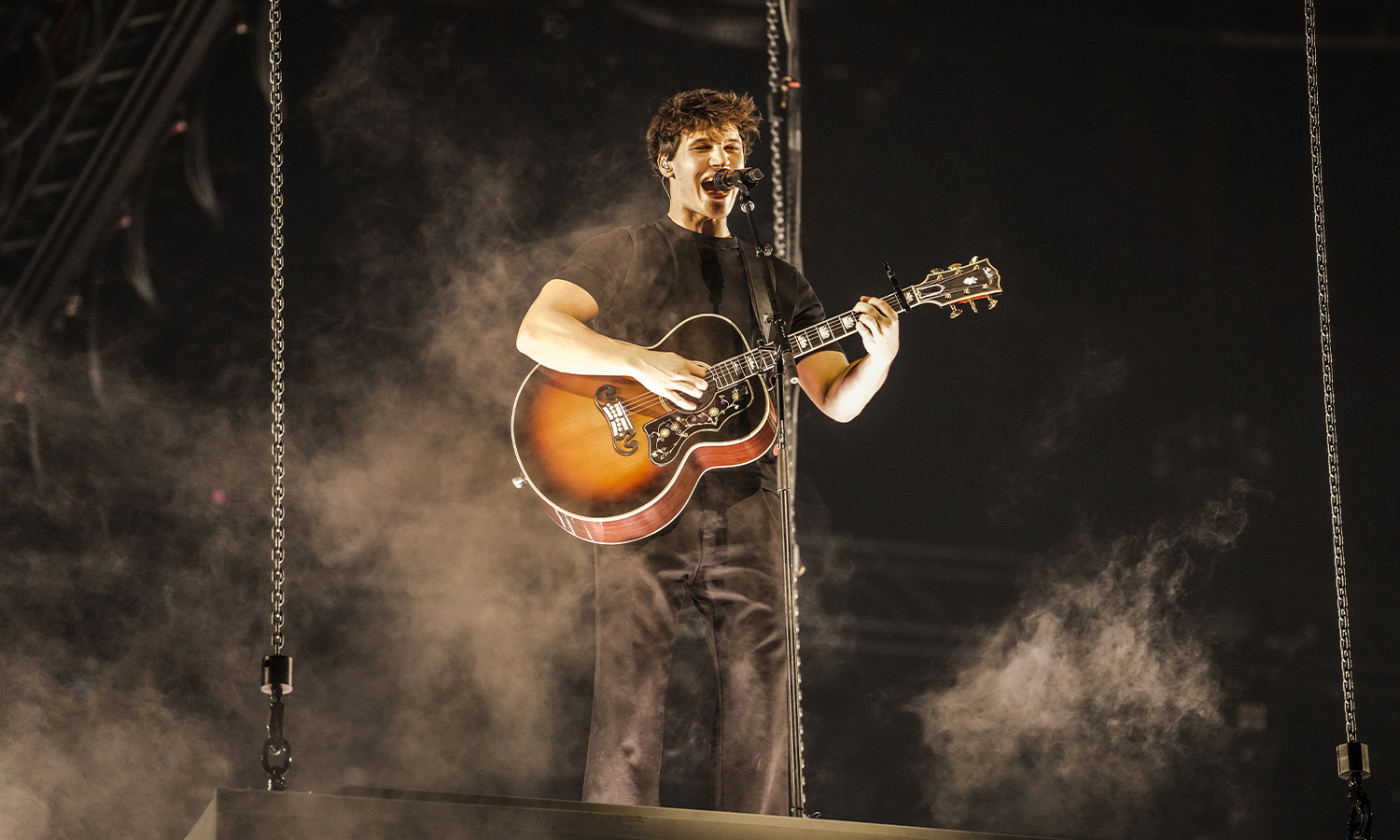 Sänger Wincent Weiss steht emotional und singend mit Mikrofon auf der großen Bühne in der SAP Arena Mannheim vor einem Lichtermeer aus Fans.